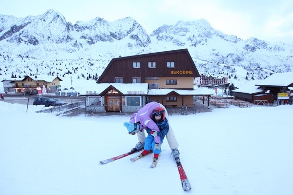 אמא עוזרת לבנה לעלות על מגלשי הסקי