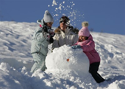 אבא וילדים בונים איש שלג