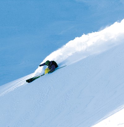 גולש סקי במדרון תלול בשלג עמוק
